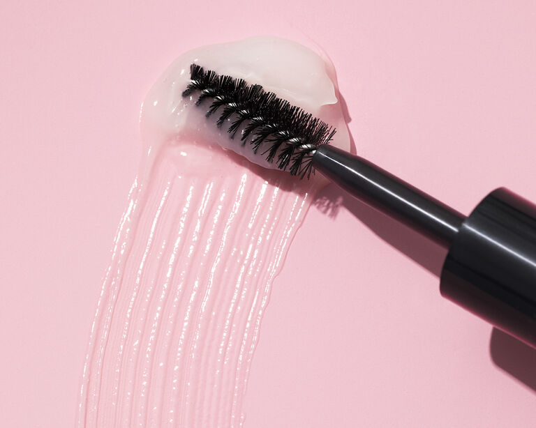 Black wand applicator on top of clear brow gel swipe
