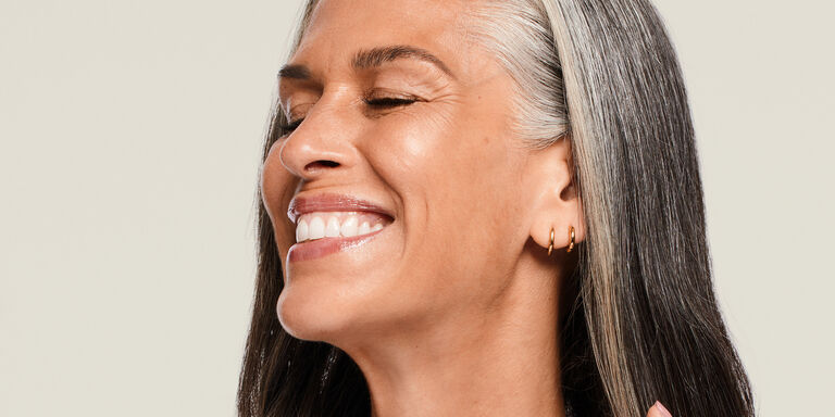 Femme d'&acirc;ge m&ucirc;r souriant, les yeux ferm&eacute;s