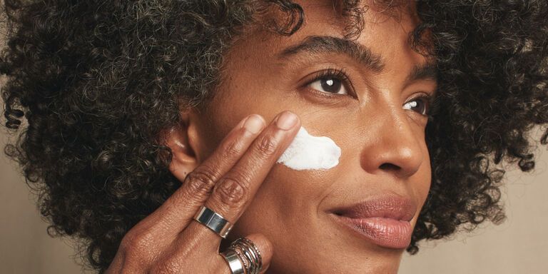 Woman with chin resting on hand wearing Timewise