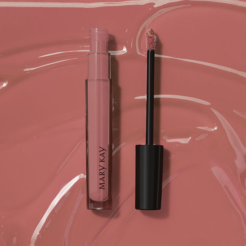 Open tube of Mary Kay Unlimited Lip Gloss in shade Nude Blush against accompanying shade rub.
