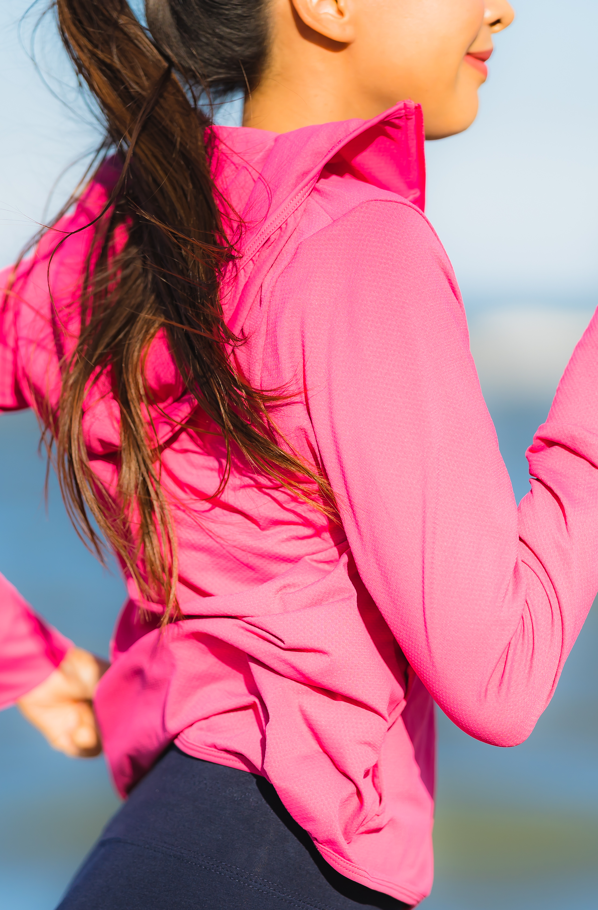 A person is running while wearing a pink jacket.