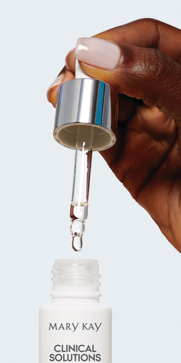Model holding Mary Kay Clinical Solutions C + Resveratrol Line-Reducer bottle and dropper