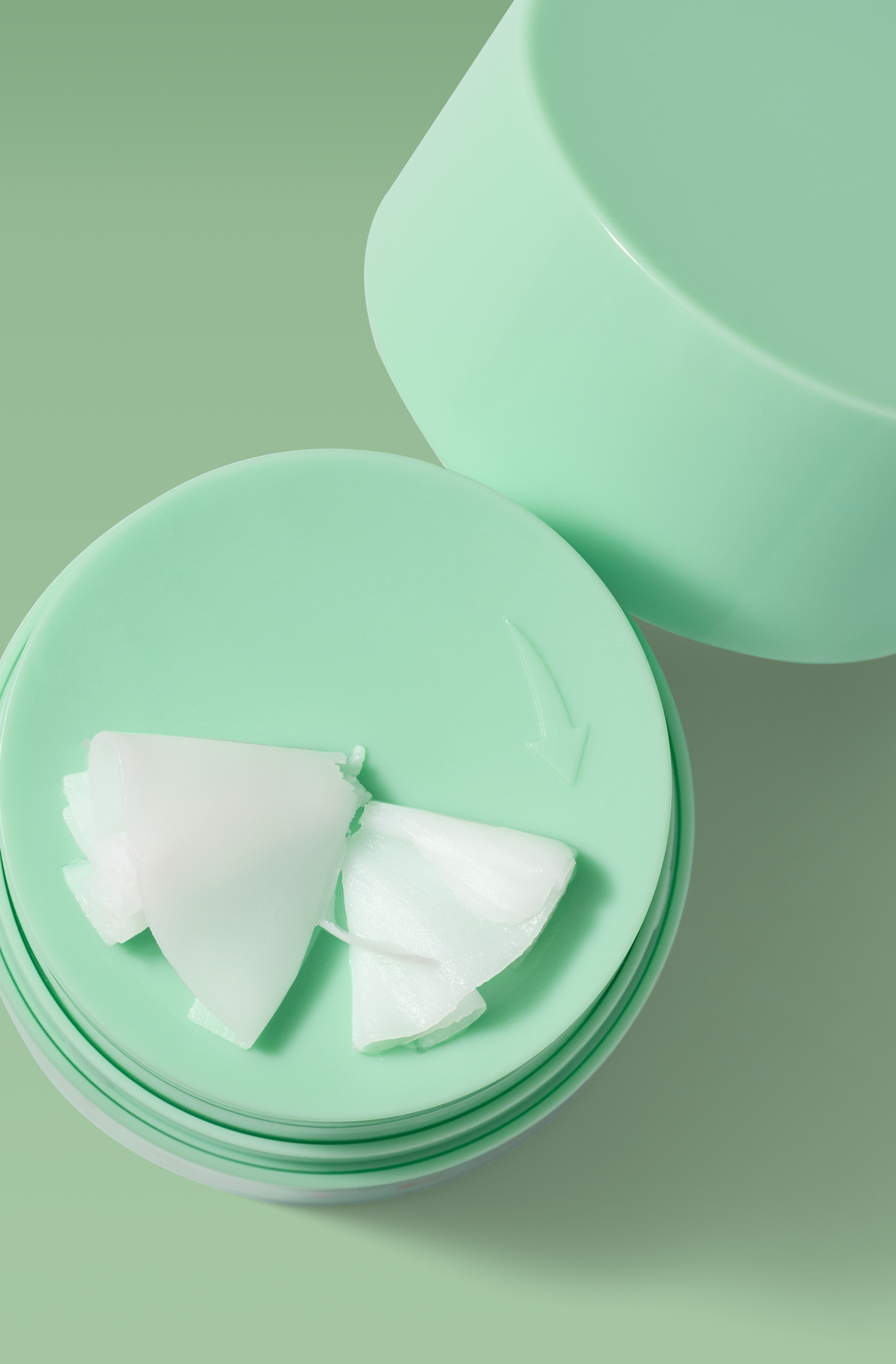 Mint green cleansing balm jar with white balm texture displayed on top