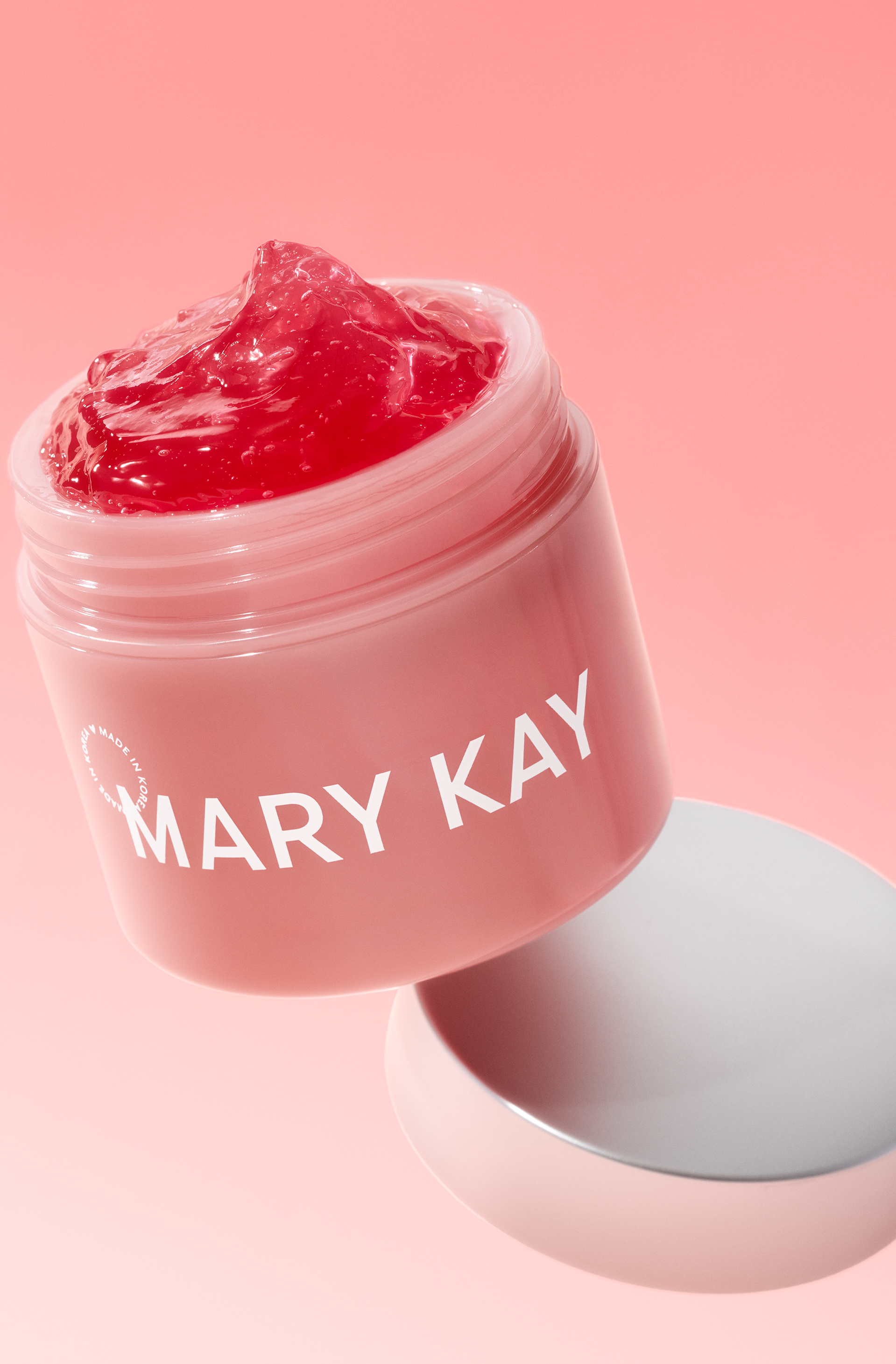Open pink Mary Kay jar containing glossy pink moisturizing gel