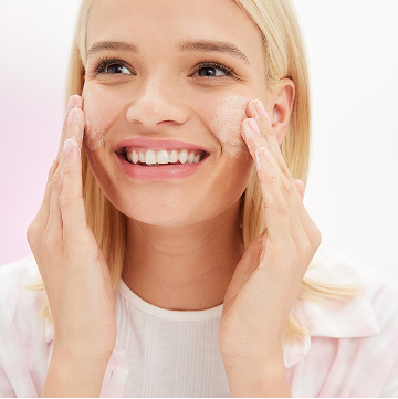 Blonde model applying Mary Kay Skin Care Balancing Toner on her face