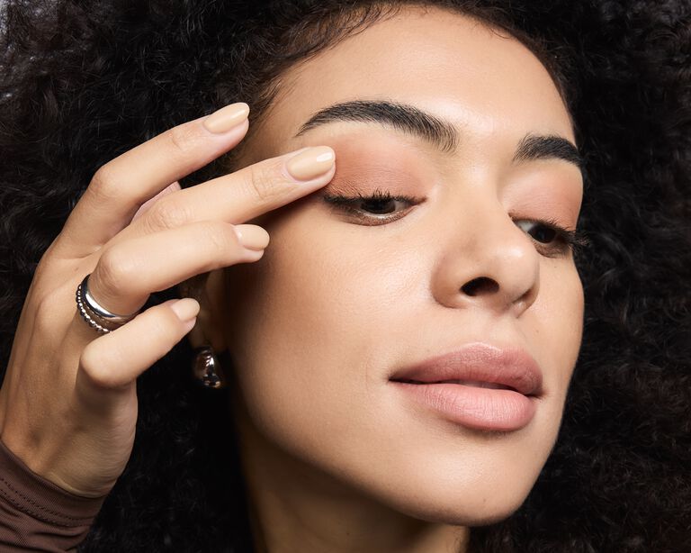 Model blending eyeshadow on her eyelid with her finger