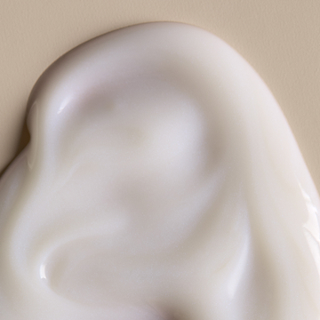 A woman's hand with drops of skin care products on it.