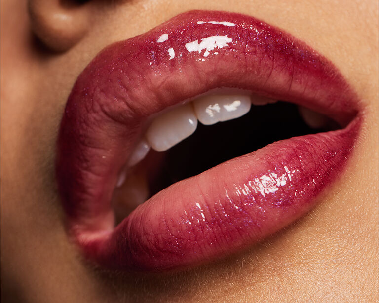 Close-up of glossy, berry-colored lips