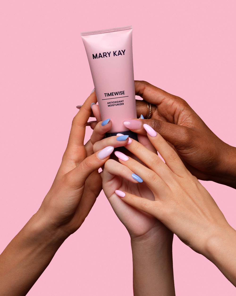 Group of women's hands holding TimeWise Antioxidant Moisturizer together