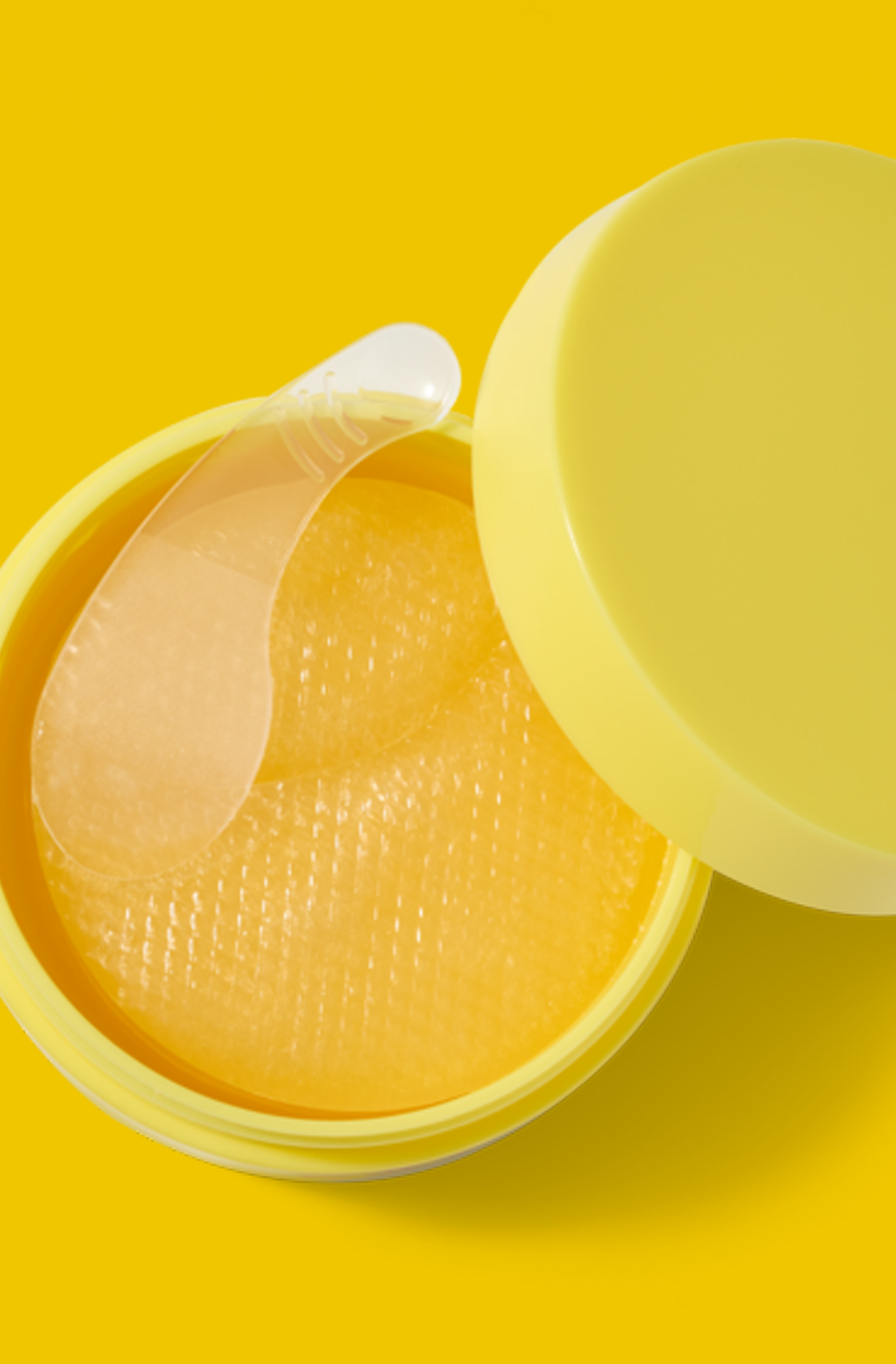 Open yellow skincare jar filled with translucent gel patches