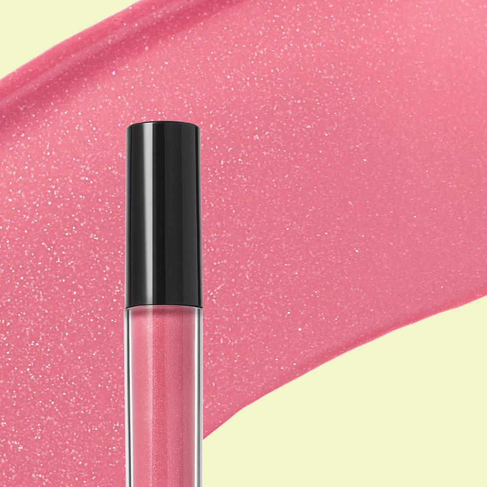 Mary Kay Unlimited Lip Gloss tube over pink lip gloss product rub