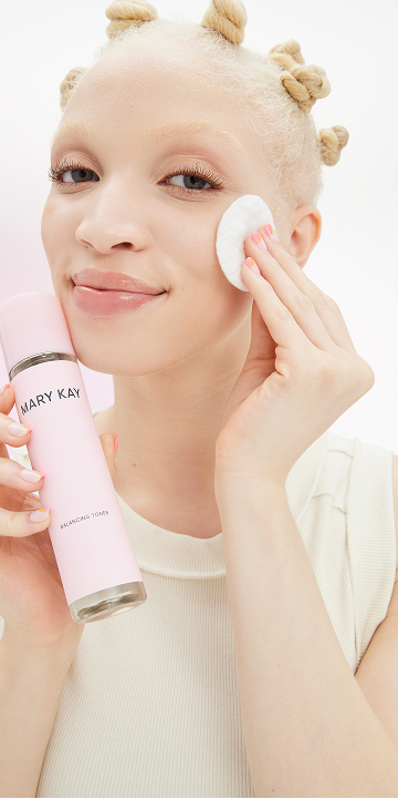 Blonde model applying Mary Kay Skin Care Balancing Toner on her cheek